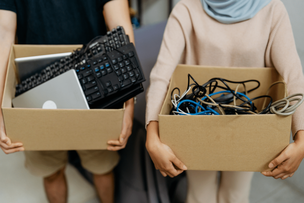 couple carrying boxes with items for electronic recycling