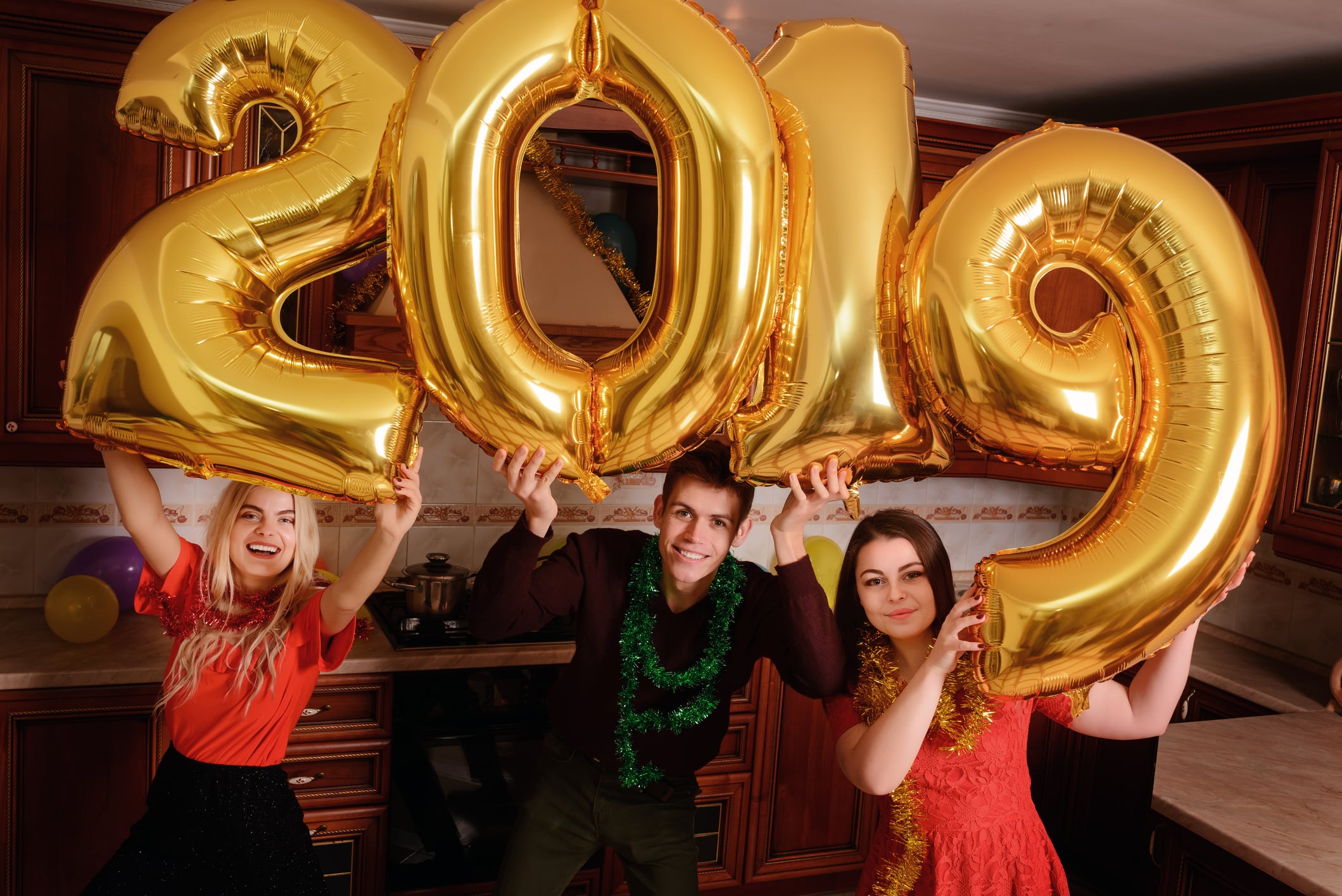 New 2019 Year is coming. Group of cheerful young people carrying gold colored numbers and have fun at the party New 2019 Year is coming. Group of cheerful young people carrying gold colored numbers and have fun at the party.