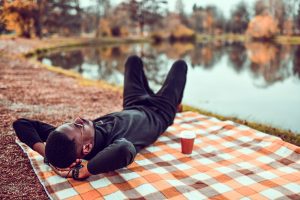 Man resting on a picnic blanket 