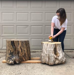 Woman sands tree stump. Self-storage Thousand Oaks share the benefits. 