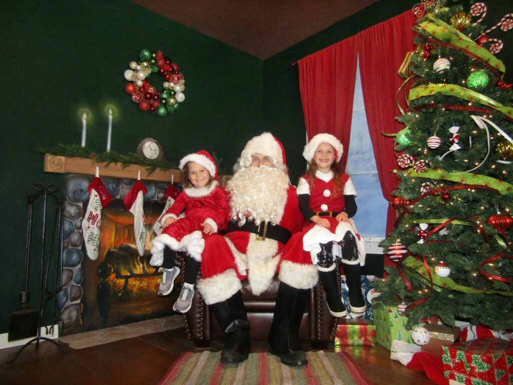 santa smiles with two little girls