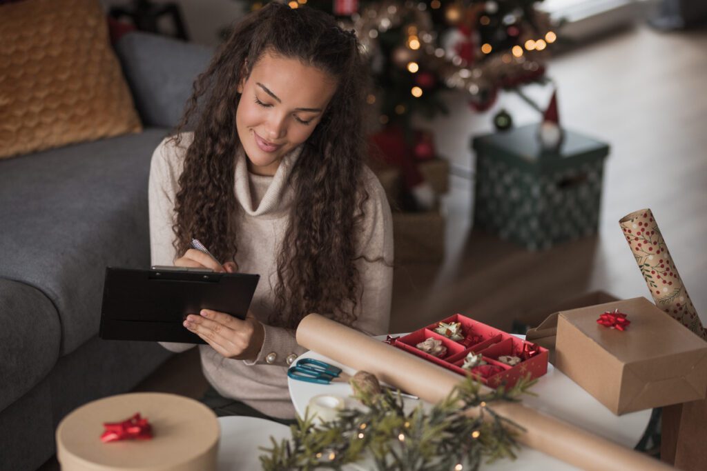 Happy young woman making a wish list for the Christmas holidays and New year